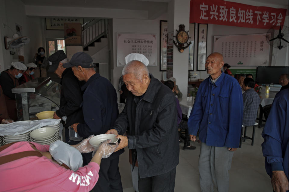 Elderly people line up for free vegetarian lunch at Kang's canteen, the Harmonious and Happy Home in Dingxing, southwest of Beijing Thursday, May 13, 2021. China's leaders are easing limits on how many children each couple can have, hoping to counter the rapid aging of Chinese society.(AP Photo/Andy Wong)