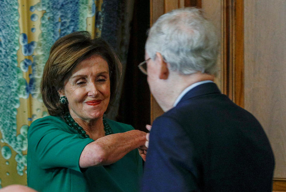 U.S. House Speaker Nancy Pelosi (D-CA) elbow bumps Senate Majority Leader Mitch McConnell (R-KY) at a Friends of Ireland luncheon on Capitol Hill in Washington, U.S., March 12, 2020. REUTERS/Tom Brenner