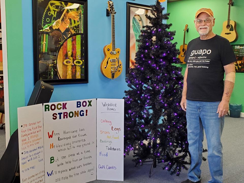 Andy Johnson, a student at Rock Box Music School in North Port, recently released a music video for his song “The Storm,” on YouTube. Here, he poses by a sign suggesting donations to help other Rock Box students, whose lives were impacted by Hurricane Ian.