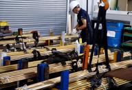 A worker at Sakai Seisakusyo prepares to transport metal rods at its factory in Kakamigahara