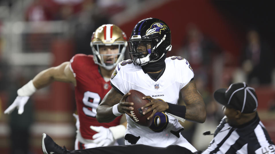 Umpire Alex Moore, bottom right, falls as San Francisco 49ers defensive end Nick Bosa, rear, chases Baltimore Ravens quarterback Lamar Jackson. (AP Photo/Jed Jacobsohn)