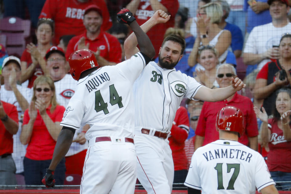 Cincinnati Reds' Aristides Aquino (44) celebrates with Jesse Winker (33) after hitting a two-run home run off Chicago Cubs starting pitcher Yu Darvish in the second inning of a baseball game, Friday, Aug. 9, 2019, in Cincinnati. (AP Photo/John Minchillo)