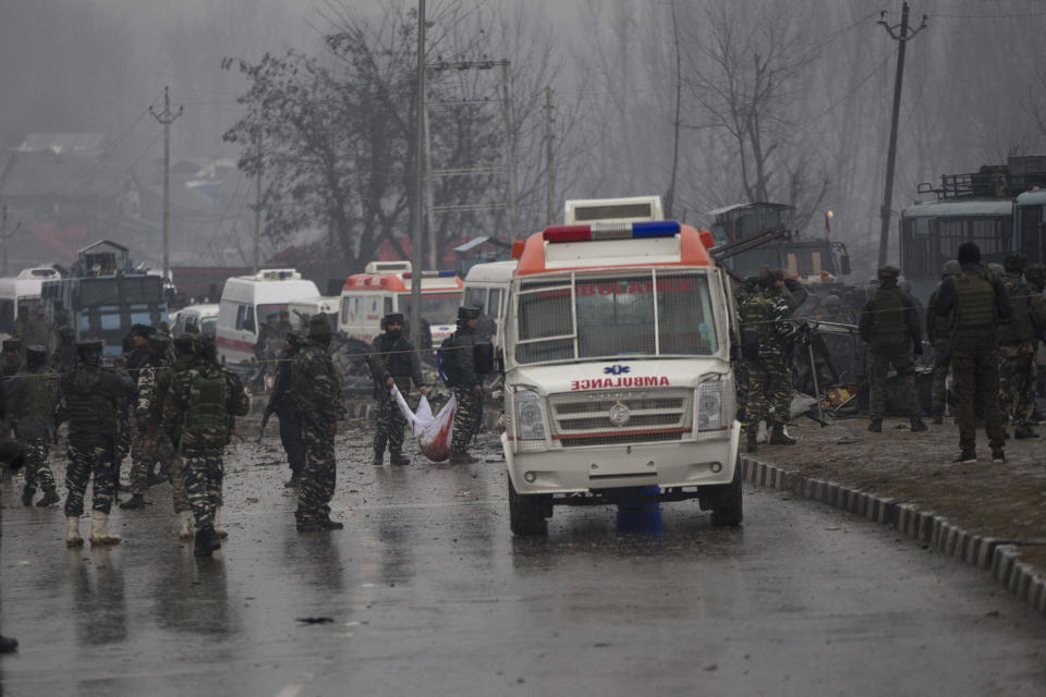 FILE - In this Feb. 14, 2019 file photo, Indian paramilitary soldiers carry the remains of colleagues at the site of a suicide bombing in Pampore, Indian-controlled Kashmir. India's anti-terrorism agency named a Pakistan-based militant leader as the prime mastermind in a 2019 car bombing in Indian-controlled Kashmir that killed 40 Indian soldiers and brought two nuclear-armed rival nations to the brink of war, officials said Wednesday. (AP Photo/Dar Yasin, File)