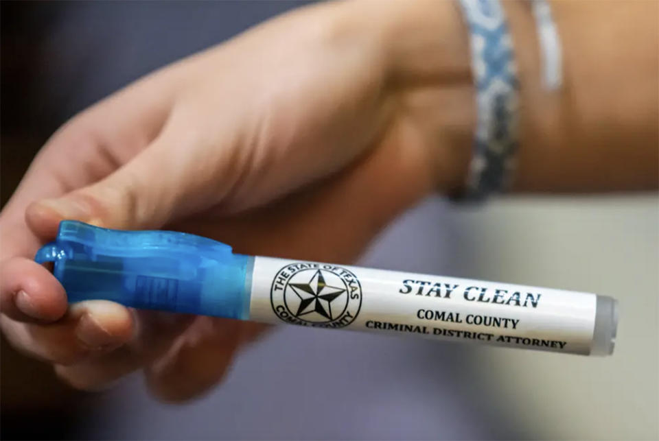 A student holds up a pen they were given during a community meeting about vaping and drug use at Smithson Valley High School on Thursday, Feb. 9, 2023 in Spring Branch TX. <cite>(Sergio Flores/The Texas Tribune</cite>)