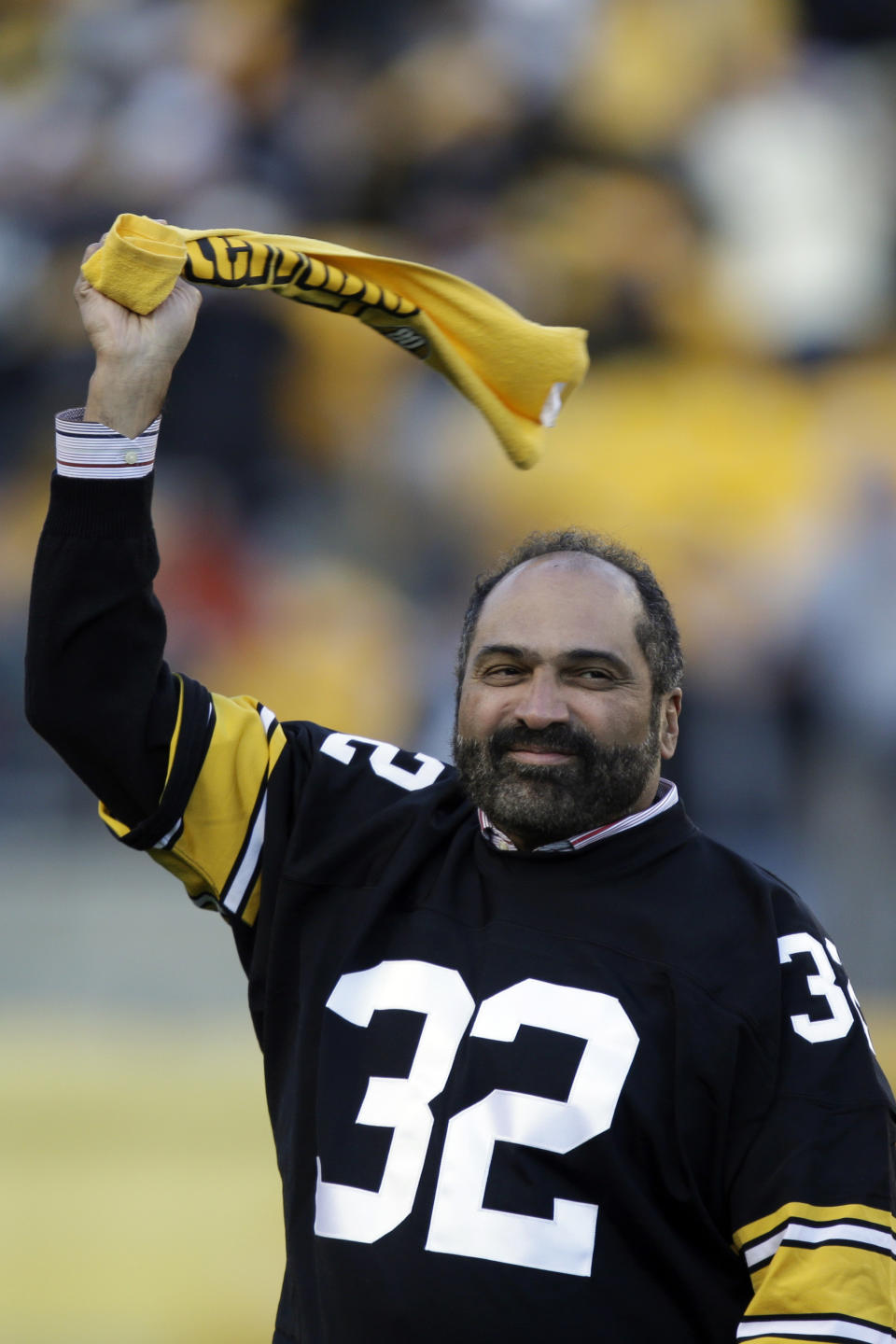 FILE - Pittsburgh Steelers Hall of Fame running back Franco Harris twirls a Terrible Towel during a ceremony commemorating the 40th anniversary of his "Immaculate Reception" catch in the 1972 playoff game against the Oakland Raiders, during the halftime of an NFL football game between the Steelers and the Cincinnati Bengals in Pittsburgh, Sunday, Dec. 23, 2012. Franco Harris, the Hall of Fame running back whose heads-up thinking authored “The Immaculate Reception,” considered the most iconic play in NFL history, died Wednesday, Dec. 21, 2022. He was 72. (AP Photo/Gene J. Puskar)