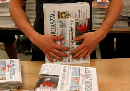 Workers assemble copies of the daily newspaper Delmagyarorszag hot off the press at publishing house Lapcom's press room in Szeged, Hungary, November 9, 2016. REUTERS/Laszlo Balogh