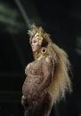 <p>Beyoncé once again channeled female deities during her performance at the 59th Annual Grammy Awards, during which she exclusively wore custom Peter Dundas. One look was essentially a gold chain bikini with a billowing yellow train and thick, gold jewellery, which, like the "Hold Up" video, pays homage to the Yoruba goddess, Oshun. The West African water deity, Mami Wata also influenced her look, indicated by her long flowing locks. Beyoncé's golden halo also references the portrayal of the Virgin Mary, who represents piety, virtue, and devotion in Christianity.</p>