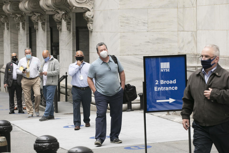 New York Stock Exchange employees wait to enter the building as the trading floor partially reopens, Tuesday, May 26, 2020. (AP Photo/Mark Lennihan)