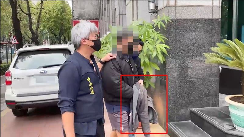 PEETA葛格被警方上銬送往警局時，雙手被外套包緊緊。（圖／翻攝畫面）