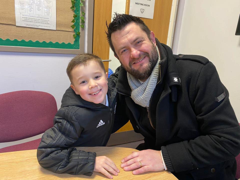 Boy and man smiling at the camera