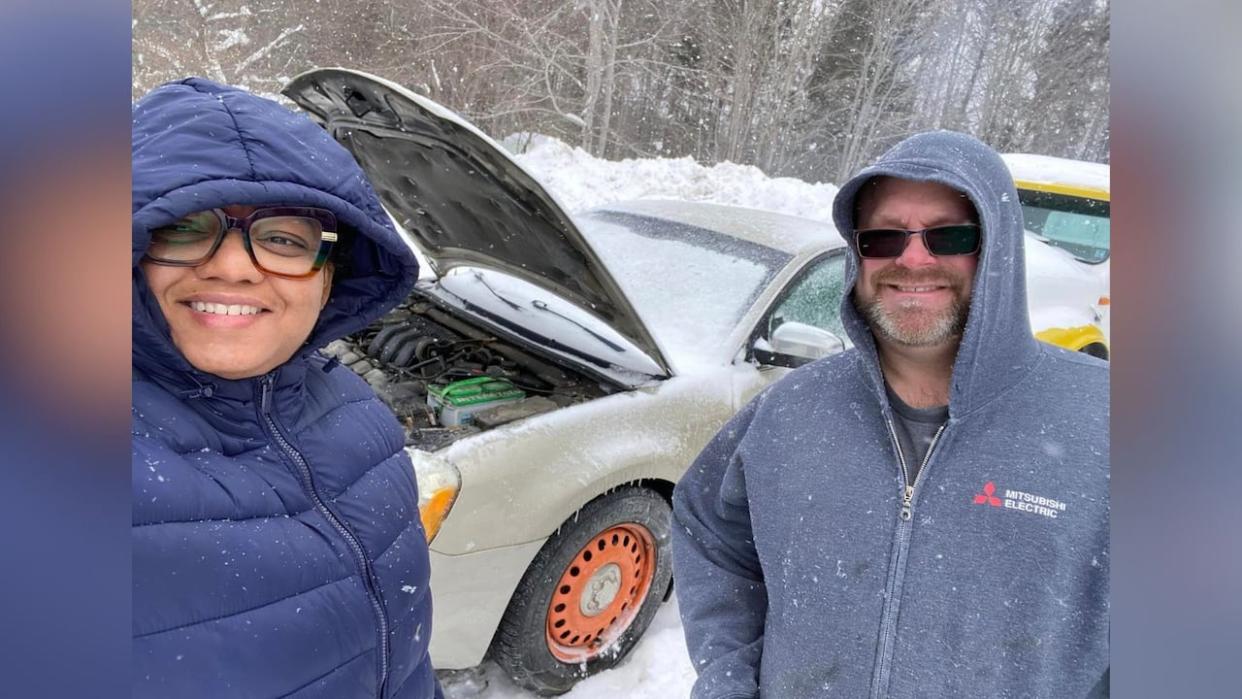 Natalie Frederick-Wilson and her husband, Dave Wilson, stand next to their stolen car after it was found in Cape Breton. They say prayers, Facebook friends and orange rims all played a part in the car being found. (Nova Scotia's Wandering Wilsons/Facebook - image credit)