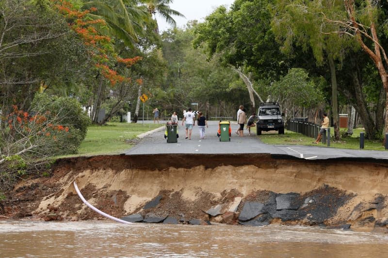 Residents are cut off after a large section of road has washed away at the end of Holloways Beach Esplanade in the suburb of Holloways Beach in Cairns. Residents in far north Queensland are bracing for more rain and further significant flooding. Joshua Prieto/AAP/dpa