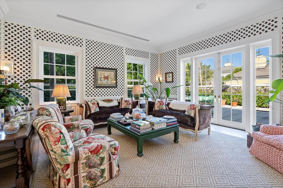 With lattice covering dark brown walls, the enclosed loggia serves as a family room.