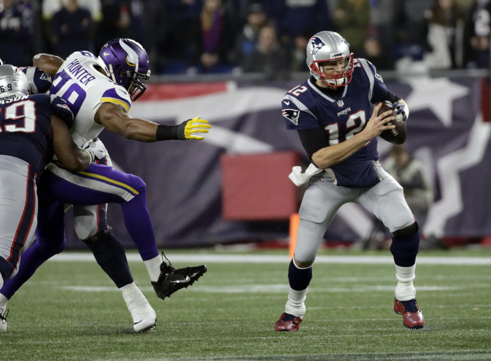 New England Patriots quarterback Tom Brady scrambles away from Minnesota Vikings defensive end Danielle Hunter (99) during the first half of an NFL football game, Sunday, Dec. 2, 2018, in Foxborough, Mass. (AP Photo/Elise Amendola)