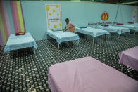 A worker arranges beds at a COVID-19 treatment facility newly set up at an indoor stadium in Gauhati, India, Monday, April 19, 2021. India's health system is collapsing under the worst surge in coronavirus infections that it has seen so far. Medical oxygen is scarce. Intensive care units are full. Nearly all ventilators are in use, and the dead are piling up at crematoriums and graveyards. Such tragedies are familiar from surges in other parts of the world — but were largely unknown in India. (AP Photo/Anupam Nath)