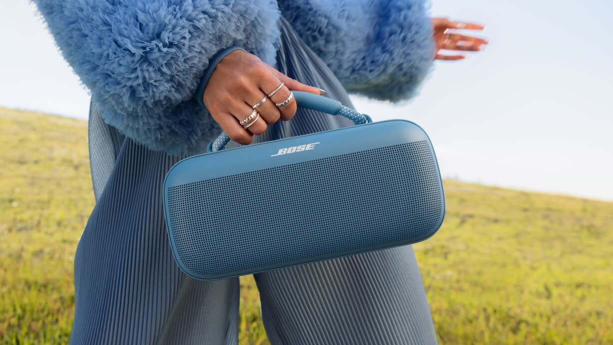  A woman holding the Bose SoundLink Max speaker. 