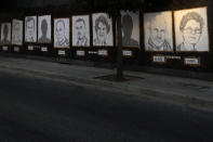 Pictures of the victims of the Aug. 4, 2020, Beirut port explosion hang on a street, in Beirut, Lebanon, Sunday, July 4, 2021. A year after the deadly blast, families of the victims are consumed with winning justice for their loved ones and punishing Lebanon's political elite, blamed for causing the disaster through their corruption and neglect. Critics say the political leadership has succeeded so far in stonewalling the judicial investigation into the explosion. (AP Photo/Hassan Ammar)