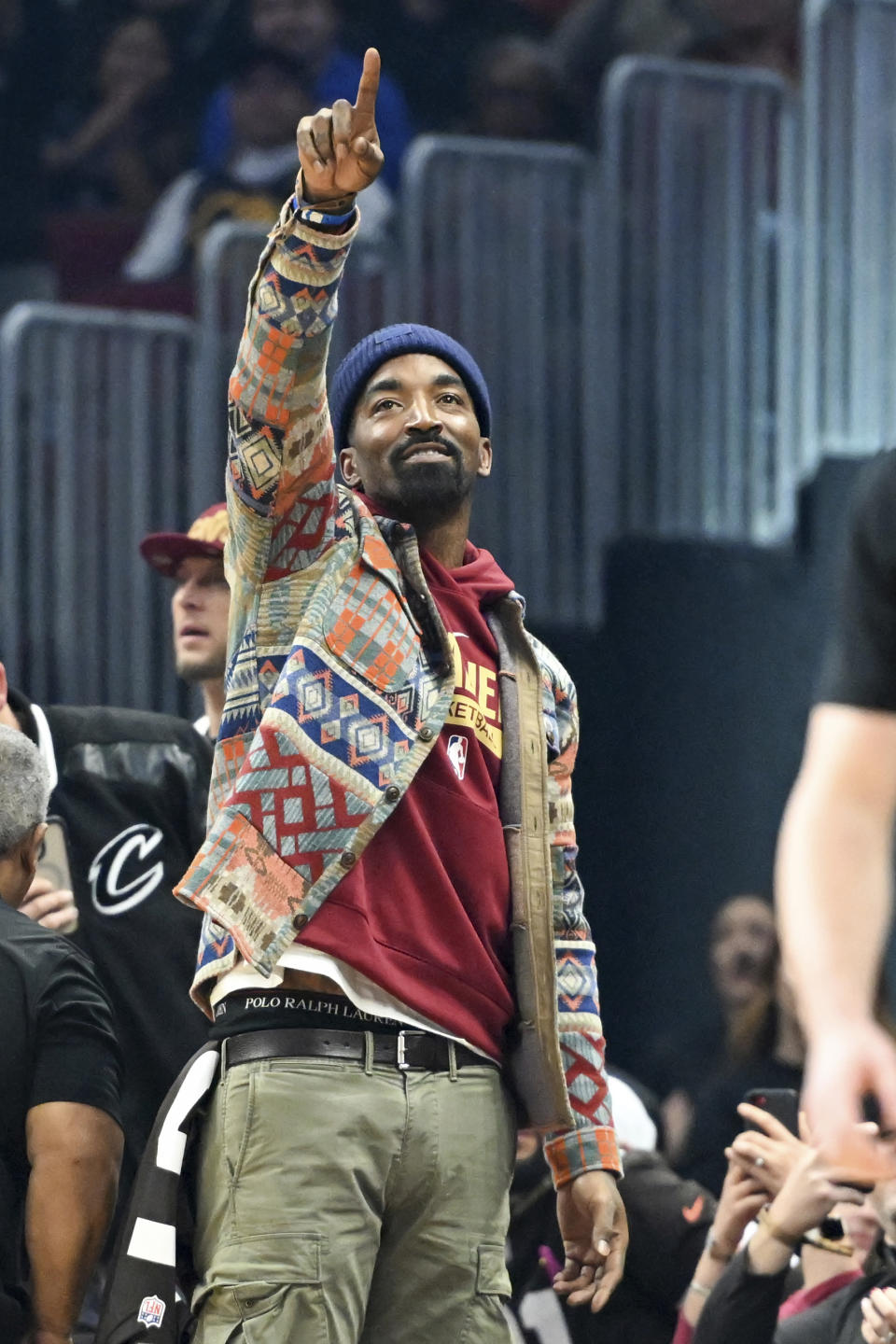 Former NBA player J.R. Smith waves to the crowd during the first half of an NBA basketball game between the Dallas Mavericks and the Cleveland Cavaliers, Saturday, Dec. 17, 2022, in Cleveland. (AP Photo/Nick Cammett)
