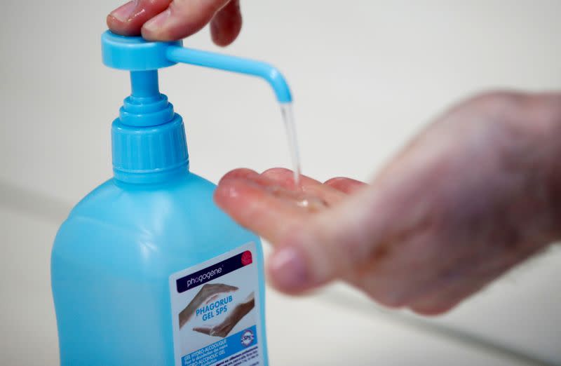 FILE PHOTO: An employee uses hydroalcoholic gel at the Christeyns company's factory in this illustration picture in Vertou