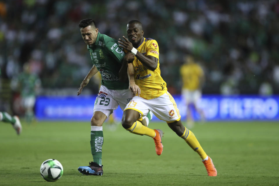 El ecuatoriano Enner Valencia (derecha), de Tigres, persigue un baló junto al argentino Ramiro González, de León, durante el partido de vuelta de la final de la liga mexicana, el domingo 26 de mayo de 2019 (AP Foto/Refugio Ruiz)