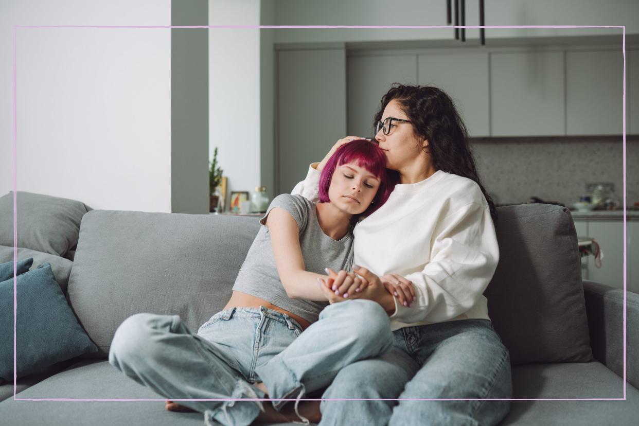  A mother hugging her son on a sofa. 