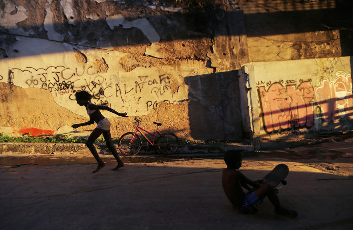 <p>Young residents play on a street passing through a set of buildings in the Mangueira favela (slum, in Portuguese) in Rio de Janeiro, May 4, 2017. Hundreds of residents who live in the occupied structures must collect water from hoses because of a shortage of running water in the buildings. A World Bank report released earlier this year states that Brazil’s deep economic crisis could push up to 3.6 million people beneath the poverty line by the end of 2017. (Photo: Mario Tama/Getty Images) </p>