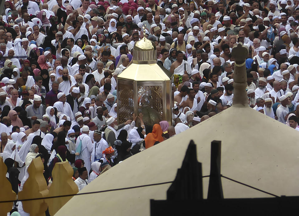 In this Feb. 24, 2020, photo, Muslim pilgrims pray near Maqam Ibrahim, or the Station of Abraham, the golden glass structure, center, at the Grand Mosque in the Muslim holy city of Mecca, Saudi Arabia. Saudi Arabia halted Thursday, Feb. 27 travel to the holiest sites in Islam over fears of the global outbreak of the new coronavirus just months ahead of the annual hajj pilgrimage, a move coming as the Mideast has over 220 confirmed cases of the illness. (AP Photo/Amr Nabil)