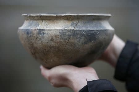 A clay pot discovered in 2006 by Archaeologists of the University of Cambridge Archaeological Unit, is displayed while they uncover Bronze Age wooden houses, preserved in silt, from a quarry near Peterborough, Britain, January 12, 2016. REUTERS/Peter Nicholls