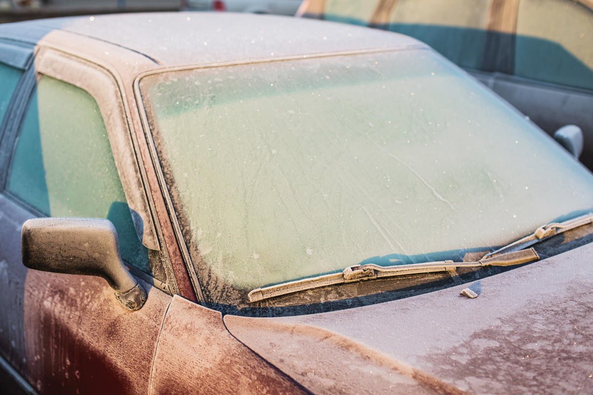 Person mit Enteiser Spray Auto Windschutzscheibe Enteisung