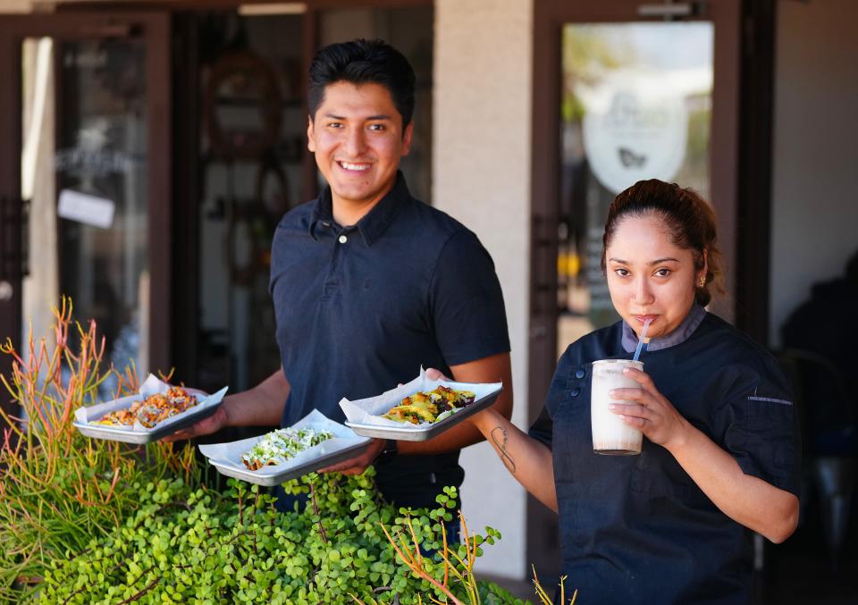 Earth Plant Based Cuisine general manager Lesem Cruz and head chef Yoseline Curiel pose with some of the delicious dishes at the restaurant on Grand Ave. in Phoenix on March 22, 2022.