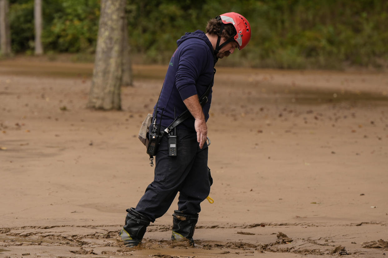 A fireman walks through mud as they search for victims of flash flooding in the aftermath of Hurricane Helene, Tuesday, Oct. 1, 2024, in Swannanoa, N.C. (AP Photo/Mike Stewart)