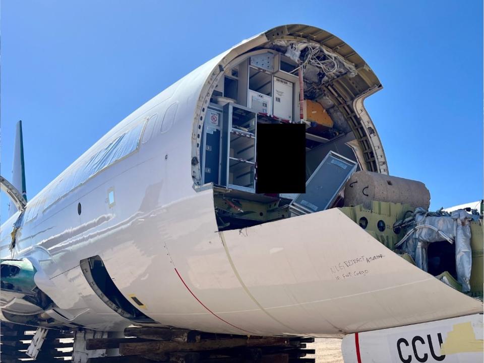 The interior of an aircraft in reclamation with the front already cut off.