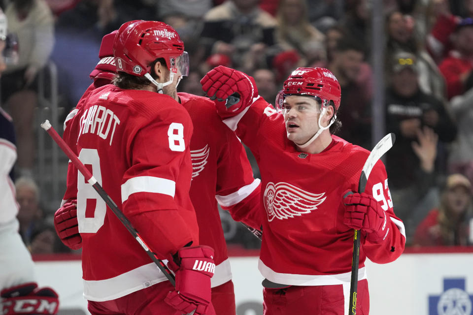 Detroit Red Wings right wing Alex DeBrincat (93) celebrates his goal with Ben Chiarot (8) against the Columbus Blue Jackets in the second period of an NHL hockey game Saturday, Nov. 11, 2023, in Detroit. (AP Photo/Paul Sancya)