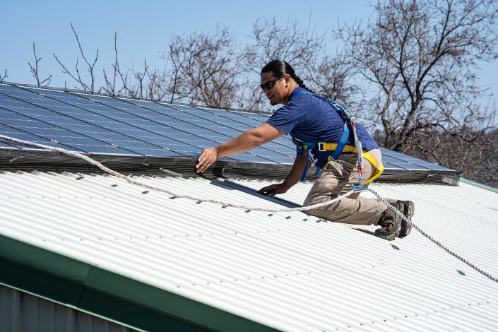 Dayne Goodheart performs an inspection of a solar array installed on a building on the Nez Perce Reservation in Lapwai, Idaho, April 1, 2021.
