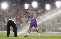 <p>Real Madrid’s Cristiano Ronaldo reacts as the sprinklers come on during the warm up before the match </p>