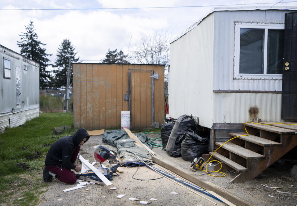 A resident at Bob’s and Jamestown Homeowners Cooperative, a resident-owned mobile home park in Lakewood, Wash., prepares to cut a baseboard as he remodels the inside of his home on Saturday, March 25, 2023. When residents learned the park’s owner was looking to sell, they formed a cooperative and bought it themselves amid worries it would be redeveloped. Since becoming owners in September 2022, residents have worked together to manage and maintain the park. (AP Photo/Lindsey Wasson)