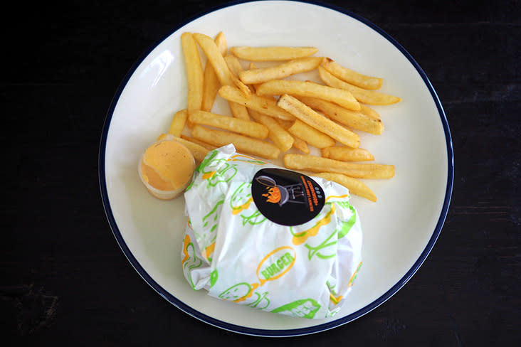 The burger is wrapped in paper and served with fries and a mild chilli mayonnaise sauce