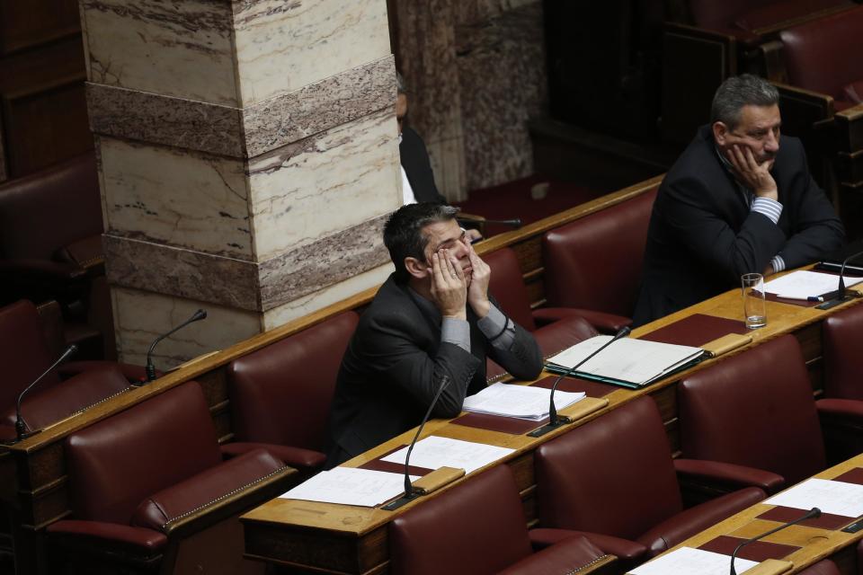 Greek lawmaker Efstathios Boukouras, whom the Golden Dawn party expelled this year and one of five party lawmakers jailed pending trial for allegedly running a criminal organization, holds his face in his hands before his speech to a parliament session in Athens, on Wednesday, May 7, 2014. Lawmakers voted Wednesday to lift the immunity from prosecution of Boukouras, two Golden Dawn lawmakers and a fourth lawmaker who has left the party, to face charges linked with a judicial crackdown on the Nazi-inspired Golden Dawn party. (AP Photo/Petros Giannakouris)