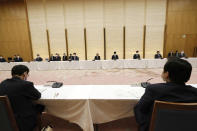 Japanese Prime Minister Yoshihide Suga, center, declares a state of emergency for Tokyo and three other prefectures during the government task force meeting for the COVID-19 measures at the prime minister's office Friday, April 23, 2021, in Tokyo. (AP Photo/Eugene Hoshiko, Pool)