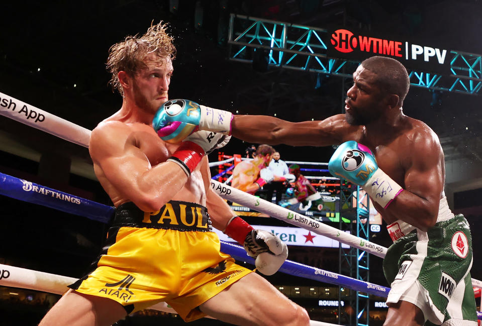 MIAMI GARDENS, FLORIDA - JUNE 06: Floyd Mayweather (R) punches Logan Paul during their contracted exhibition boxing match at Hard Rock Stadium on June 06, 2021 in Miami Gardens, Florida. (Photo by Cliff Hawkins/Getty Images)