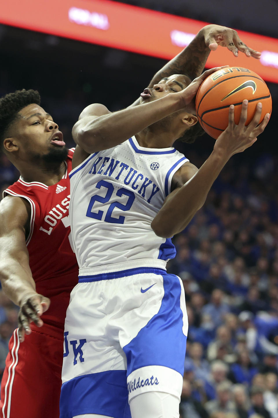 Kentucky's Cason Wallace (22) tries to shoot as Louisville's Sydney Curry (21) defends during the first half of an NCAA college basketball game in Lexington, Ky., Saturday, Dec. 31, 2022. (AP Photo/James Crisp)