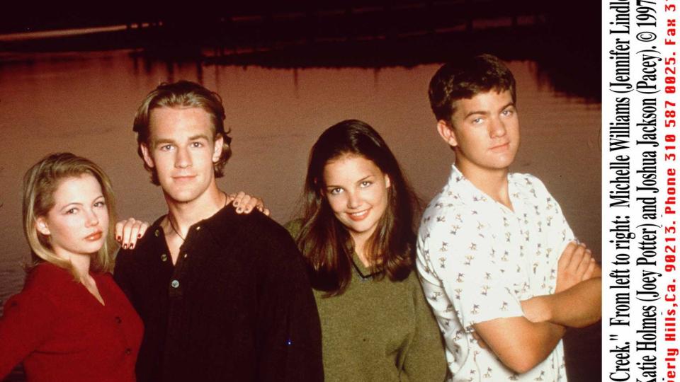 michelle williams, james van der beek, katie holmes, and joshua jackson stand next to each other for a photo with a body of water and a sunset behind them