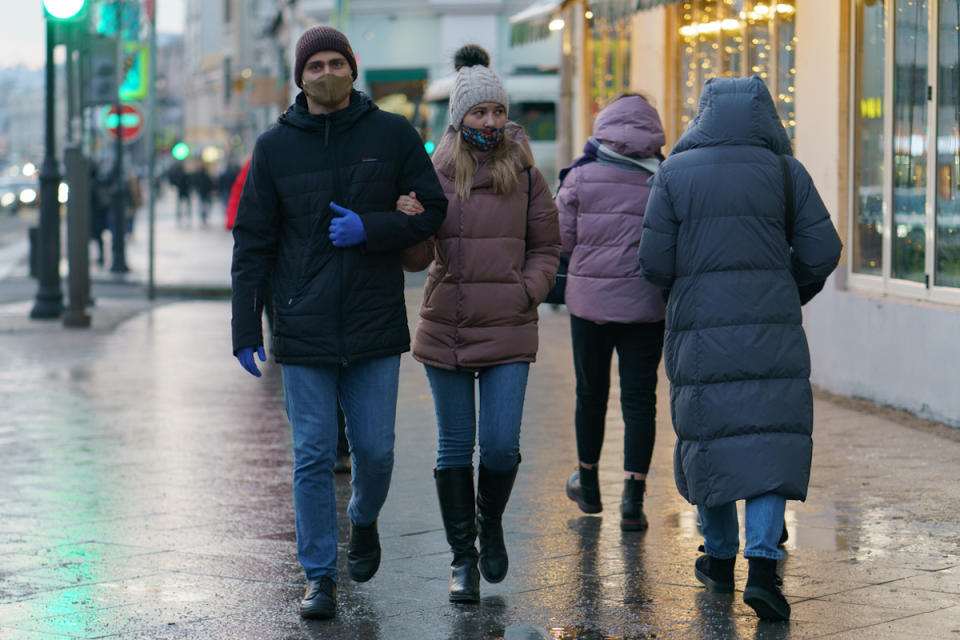 people wearing protective masks against COVID in city streets in winter