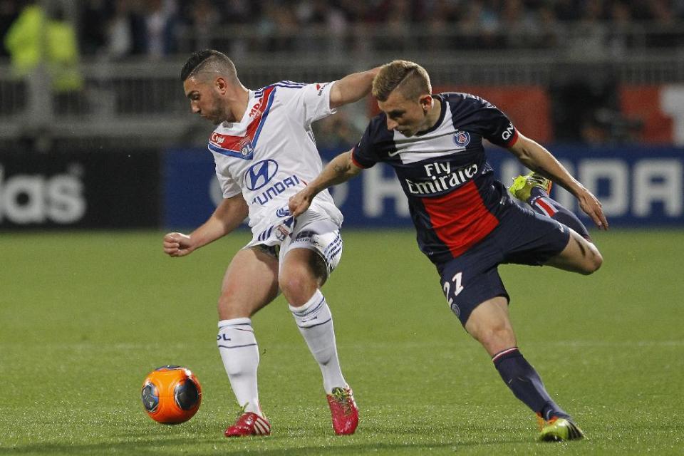 Lyon's Jordan Ferri, left, challenges for the ball with Paris Saint Germain's Lucas Digne, right, during their French League One soccer match in Lyon, central France, Sunday, April 13, 2014. (AP Photo/Laurent Cipriani)