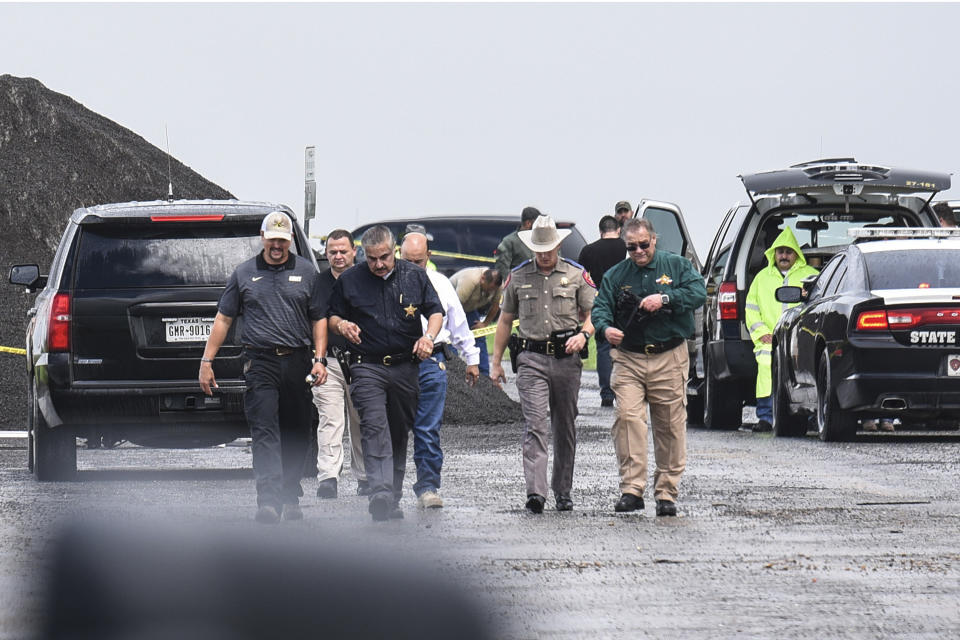 Law enforcement officers gather near the scene where the body of a woman was found near Interstate 35 north of Laredo, Texas on Saturday, Sept. 15, 2018. A U.S. Border Patrol agent suspected of killing four women was arrested early Saturday after a fifth woman who had been abducted managed to escape from him and notify authorities, law enforcement officials said, describing the agent as a "serial killer." (Danny Zaragoza/The Laredo Morning Times via AP)