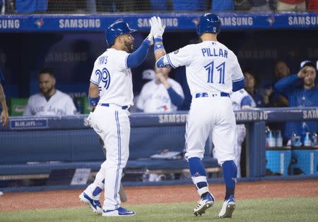 Mar 29, 2018; Toronto, Ontario, CAN; Toronto Blue Jays center fielder Kevin Pillar (11) celebrates with second baseman Devon Travis (29) after hitting a home run in the eighth inning during the home opener against the New York Yankees at Rogers Centre. Mandatory Credit: Nick Turchiaro-USA TODAY Sports