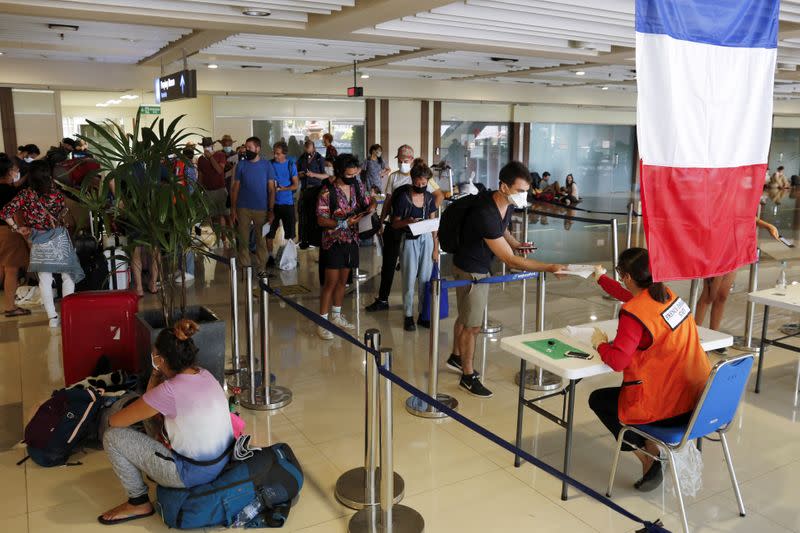 Visitors queue to register their documents before their chartered flight back to their country at Ngurah Rai International Airport in Bali