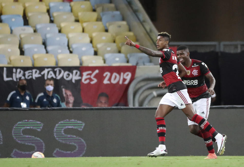 Bruno Henrique del Flamengo de Brasil, izquierda, celebra tras anotar el tercer gol de su equipo contra el Junior de Colombia durante un partido por el cierre del Grupo A de la Copa Libertadores en el estadio Maracaná de Río de Janeiro, Brasil, el miércoles 21 de octubre de 2020. (Sergio Moraes/Pool, vía AP).