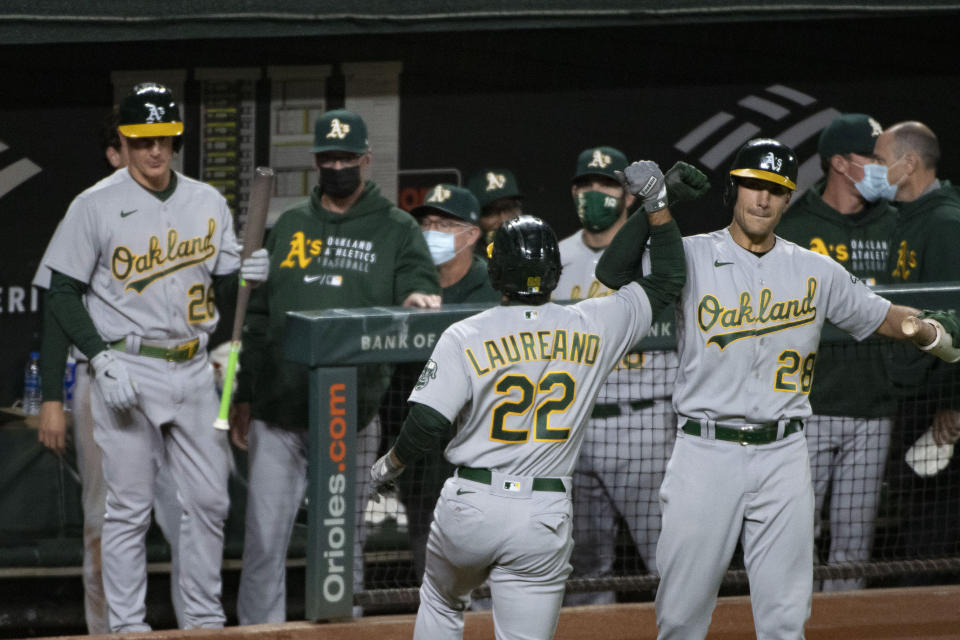 Oakland Athletics' Ramon Laureano (22) celebrates with Matt Olson after hitting a solo home run during the fifth inning of the team's baseball game against the Baltimore Orioles, Friday, April. 23, 2021, in Baltimore. (AP Photo/Tommy Gilligan)