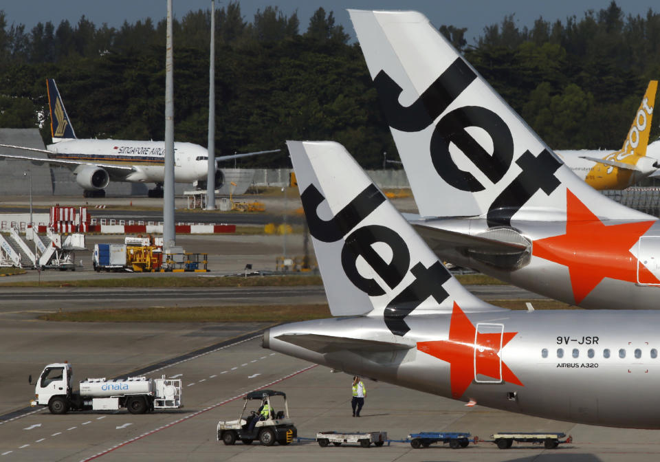 Image showing two parked Jetstar aircrafts with Scoot and SIA aircrafts behind them. 